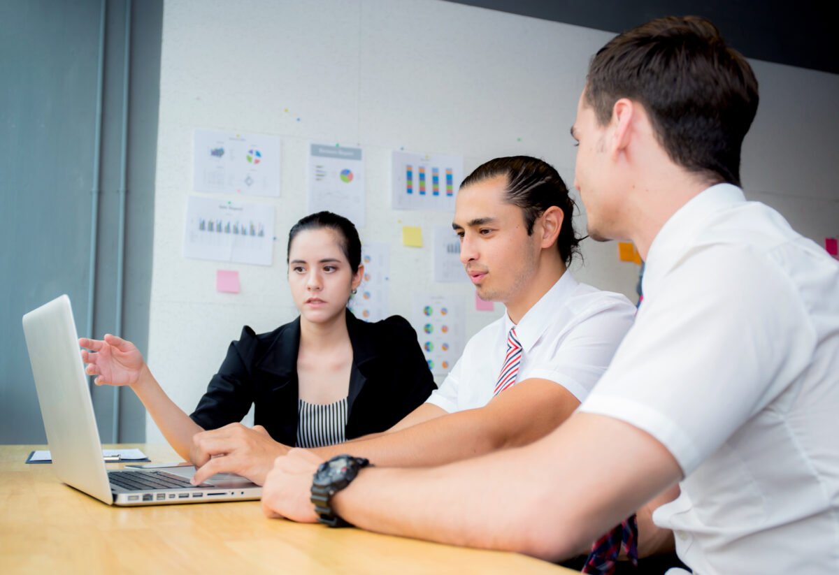 access to work autism support worker ofering advice during business meeting around a laptop